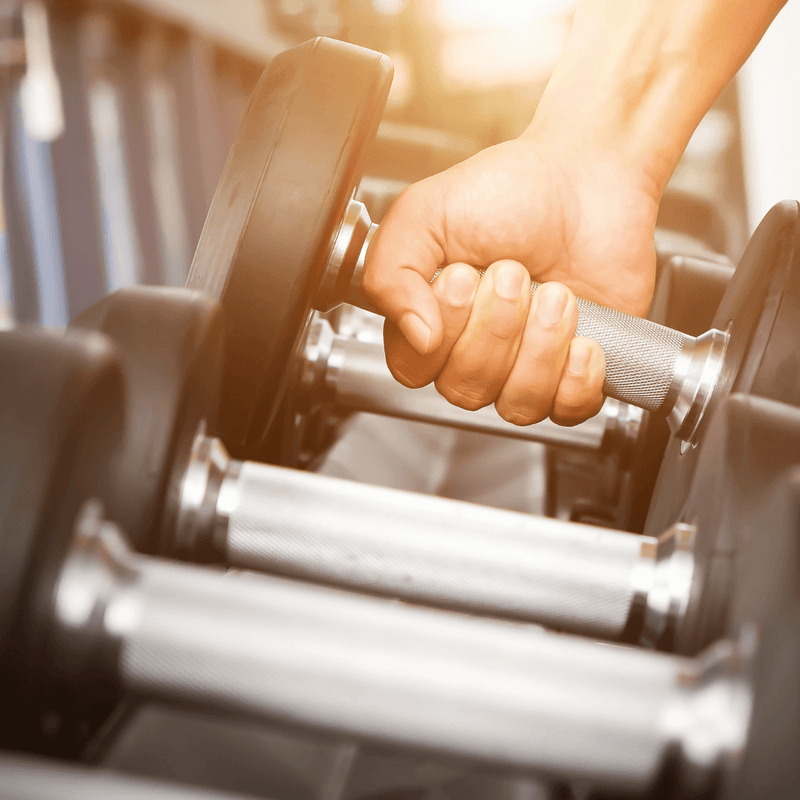 A close-up of a hand gripping a dumbbell, representing strength training in Your Ultimate Guide to Home Workouts for Women.
