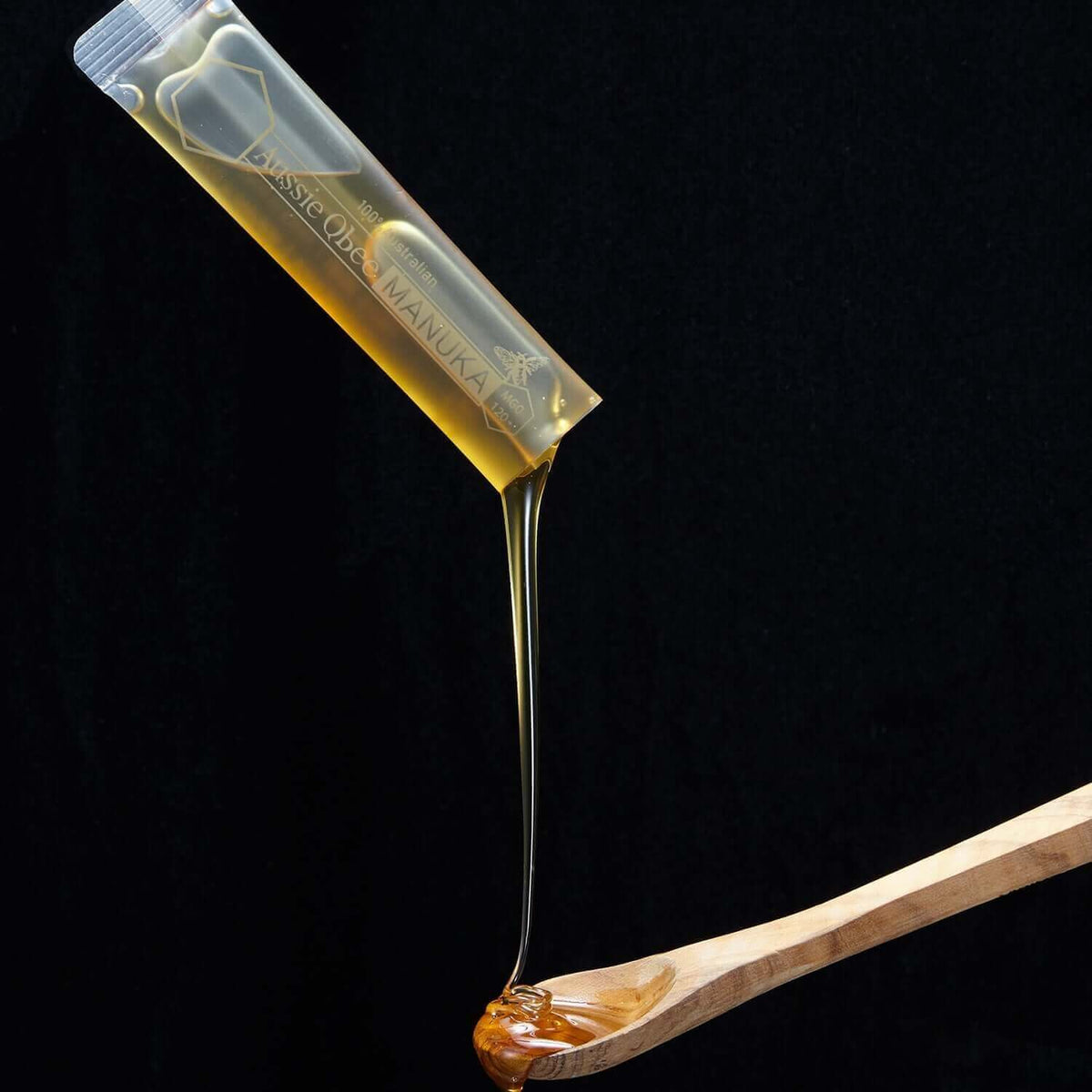 MGO 150+ Manuka honey gift package featuring premium Australian Manuka honey dripping from a spoon.