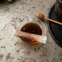 MGO 150+ Manuka honey gift package shown in a glass bowl with honey dipper, perfect for sharing and gifting.