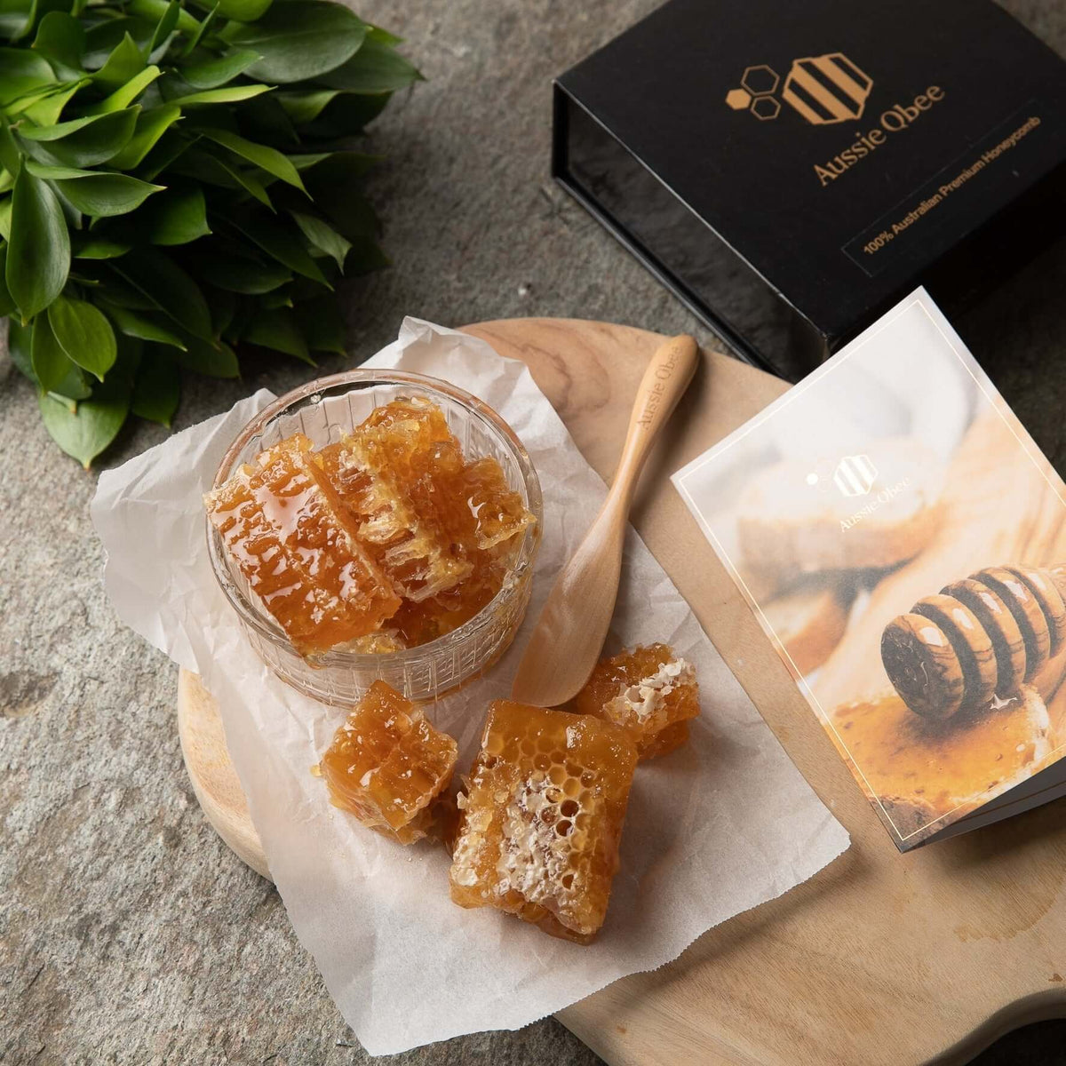 Premium Natural Honeycomb 400g displayed in a glass jar on a wooden board with packaging and spoon.