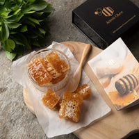 Premium Natural Honeycomb 400g displayed in a glass jar on a wooden board with packaging and spoon.