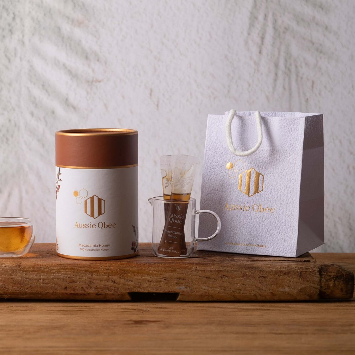Macadamia Honey 360g in a stylish canister with a glass and bag, showcasing premium Australian honey.