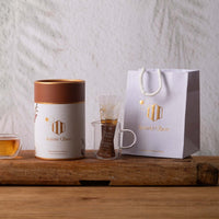 Macadamia Honey 360g in a stylish canister with a glass and bag, showcasing premium Australian honey.