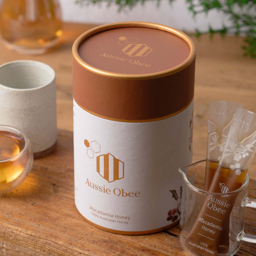 Ironbark & Macadamia Honey gift package on a wooden table, featuring Aussie Qbee Macadamia Honey.