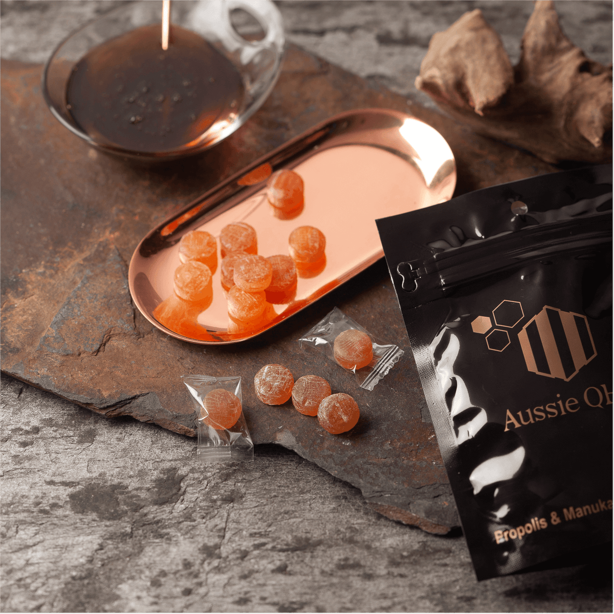 Propolis Lozenges on a copper tray with Manuka honey, showcasing Aussie Q product packaging.