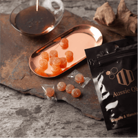 Propolis Lozenges on a copper tray with Manuka honey, showcasing Aussie Q product packaging.